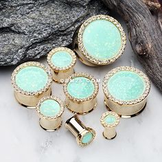 six gold and turquoise colored knobs on a rock