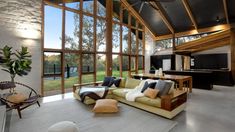 a living room filled with lots of furniture and large glass windows over the top of it