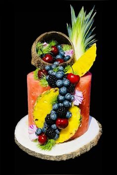 a watermelon and pineapple cake with fruit on top