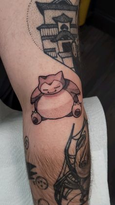 a man's leg with a cartoon character tattoo on it, and an image of a cat