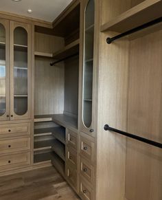 an empty walk - in closet with wooden cabinets and drawers