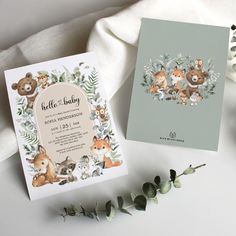 two cards with animals on them next to some flowers and leaves, one is for a baby shower