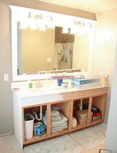 a bathroom with a large mirror and white cabinets