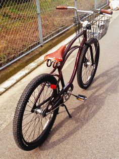 a bicycle parked next to a fence on the street