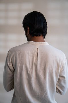 100% Cotton • Hand Spun • Hand Woven • Undyed • Unbleached • Embroidery DetailThis Dawning Panelled Long Shirt comes in a calm and soothing colour that we call Kora. Crafted in 100% cotton fibres and natural materials. This Kala Cotton shirt is undyed and unbleached. It has a band collar and full front panelling. This full-sleeve shirt comes with two patch pockets that are extensively adorned with stitches of Kantha, a form of Indian hand embroidery.Type of Button used: Coconut Shell Buttons