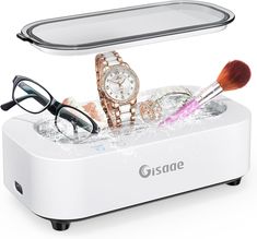 a watch, glasses and other items are in an ice cube with water on it