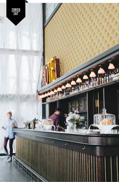 two people are standing at the counter in a restaurant