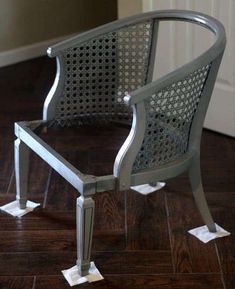 a metal chair sitting on top of a hard wood floor next to a white door