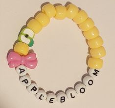 a yellow rubber bracelet with an angry bird and name bead on it that says appleblow