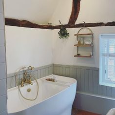 an old fashioned bathtub in a bathroom with exposed wood beams on the ceiling and walls