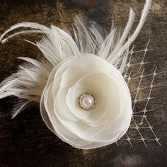 a white flower and some feathers on a table