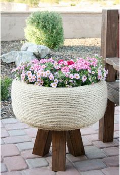 an old tire turned into a gorgeous planter with rope and flowers in the center