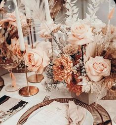 a table setting with flowers and candles