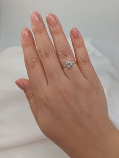 a woman's hand with a diamond ring on it