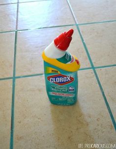 a bottle of cleaner sitting on top of a tiled floor