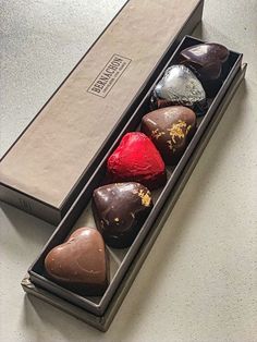 four heart shaped chocolates in a gift box