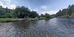 a man is fishing on the river bank