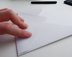 a person's hand on top of an envelope