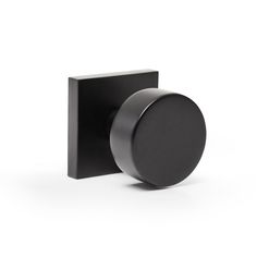 an image of a black square knob on a white background with the door handle open