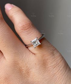 a woman's hand with a diamond ring on it