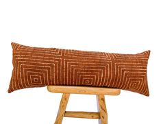 a brown and white pillow sitting on top of a wooden stool