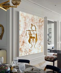 a painting hanging on the wall above a dining room table with place settings and chairs