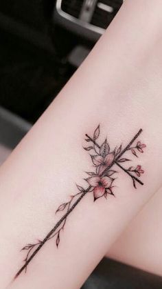 a woman's leg with a flower tattoo on the side of her arm,