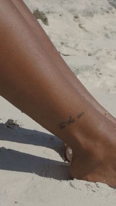 a close up of a person's foot in the sand