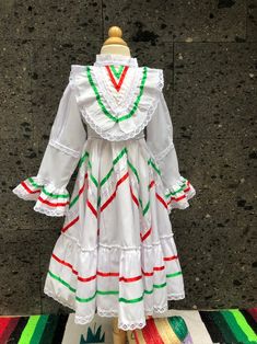 "1 Mexican size 2 Jalisco ONE PIECE White DRESS SIZE 2 Ask for different sizes and colors - kids WAIST TO FLOOR 21 inches Top to waist 10.5\"inches Waist 12 inches sleeve 16 armpit to armpit 13 inches from shoulder to shoulder 13 inches It has ties in the front that go all the way back to tie. the order of the Ribbon may change Look in our store for other handmade products of Mexico. www.mexicotodocorazon.com Note: All color embroidery is slightly different, every dress is handmade, so they are Traditional White Dress With Ruffles, Fitted Multicolor Peasant Dress, Fitted Multicolor Dress For Cinco De Mayo, White Dress For Cinco De Mayo Festival, White Dresses For Cinco De Mayo Fiesta, Jalisco Dress, Kids White Dress, Mexican Boho, Frida Kahlo Style