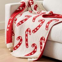 a white couch with a red and white blanket on it