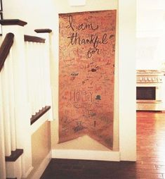 a wall with writing on it in a kitchen next to stairs and an open door