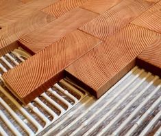 wood flooring being laid out on top of a wooden floor with metal grates