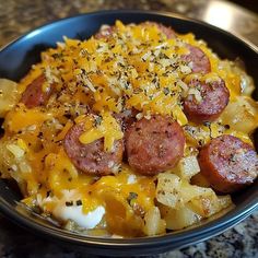 a bowl filled with pasta and sausage covered in cheese