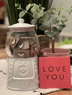 there is a vase with flowers in it next to a sign that says love you