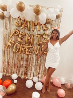 a woman posing in front of balloons and streamers