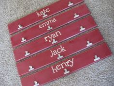 four wooden signs with names on them sitting on the floor in front of a carpet