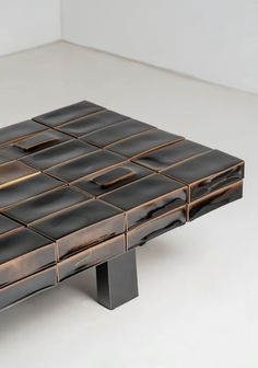 a table made out of black and gold tiles on top of a white countertop