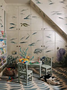 a child's room with fish painted on the wall and toys in the floor