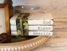 three books are stacked on top of each other in front of a bowl and plate