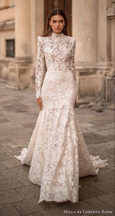 a woman in a wedding dress standing on the street