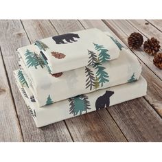 three sheets with bear and pine trees on them, one is folded in front of the other