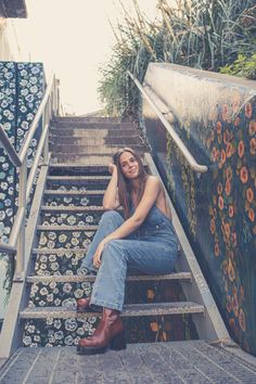 a woman is sitting on the stairs with her legs crossed