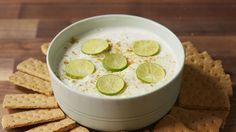 a white bowl filled with cucumber and limes on top of crackers