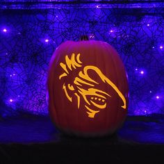 a pumpkin with an image of a lion on it in front of a purple background