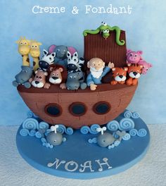 there is a cake made to look like a boat with animals on it and the name noah