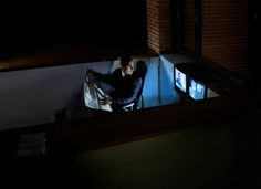 a man sitting on a chair in the dark