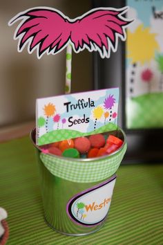 a bucket filled with candy sitting on top of a table next to a sign that says truffla seeds