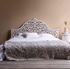 a white bed sitting on top of a wooden floor