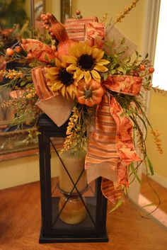 a vase filled with sunflowers and other flowers on top of a wooden table