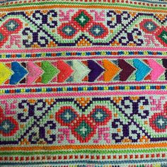 a colorful rug with many different colors and designs on the side, including an arrow